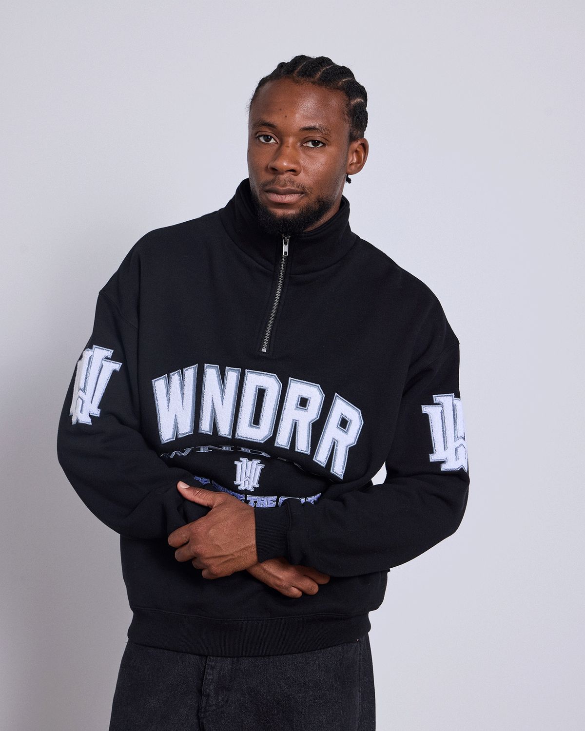 Men wearing the Wndrr Institute 1/4 Zip Sweat fleece in jet black with Wndrr brand on the chest and sleeves