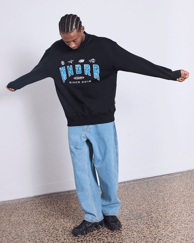 Full length view of a mand wearing the WNDRR Hashi Crew Sweat showing the oversized fit elastic cuffed sleeves and waist band