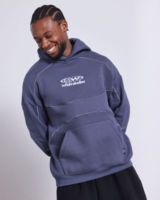 man wearing the Wndrr Globe Panel Hood fleece in an over sized fit with a kangaroo pocket white embroidered logo on the chest