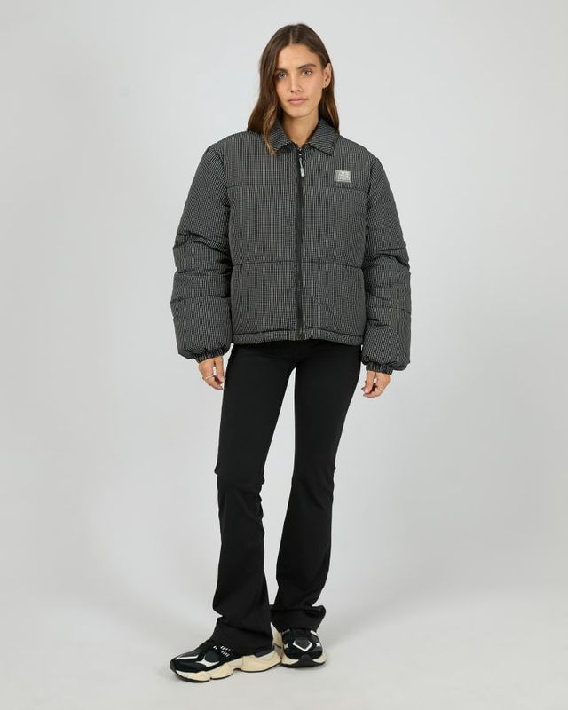 Full Body view of a model wearing the In Check Puffer jacket featuring a black an white checked pattern 