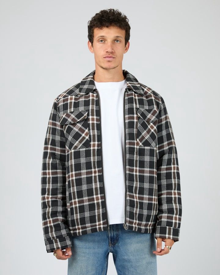 Man wearing th Saint Golaith Hanilton Jacket featuring white, brown and black check pattern