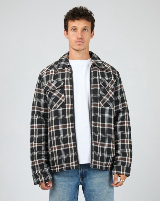 Man wearing th Saint Golaith Hanilton Jacket featuring white, brown and black check pattern