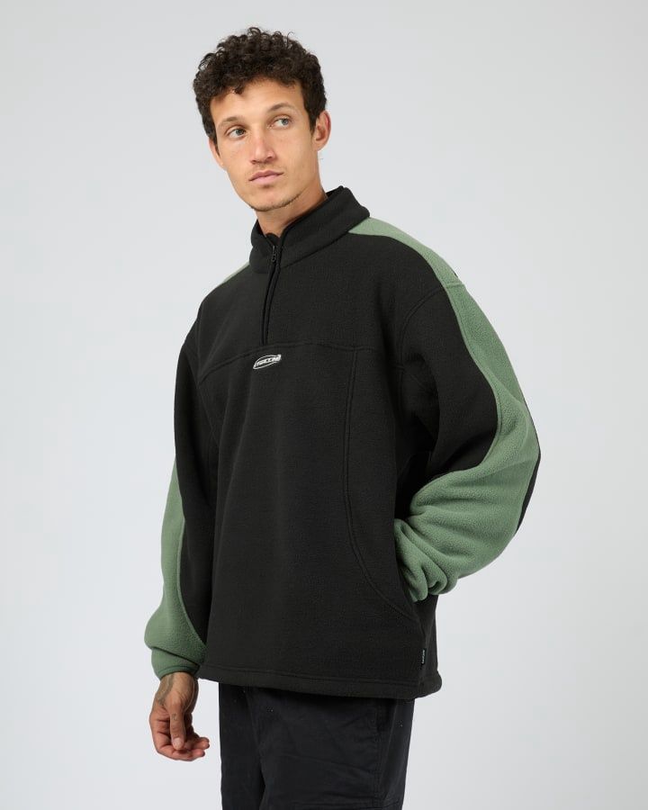 male model wearing Hyperdrive Polar Fleece Jacket by St Goliath featuring quater zip in black and green 