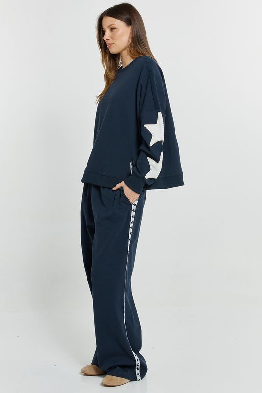 side view of a women wearing the Betty Basics Saskia Sweatshirt in Navy showing the boxy oversized fit with slights on waist