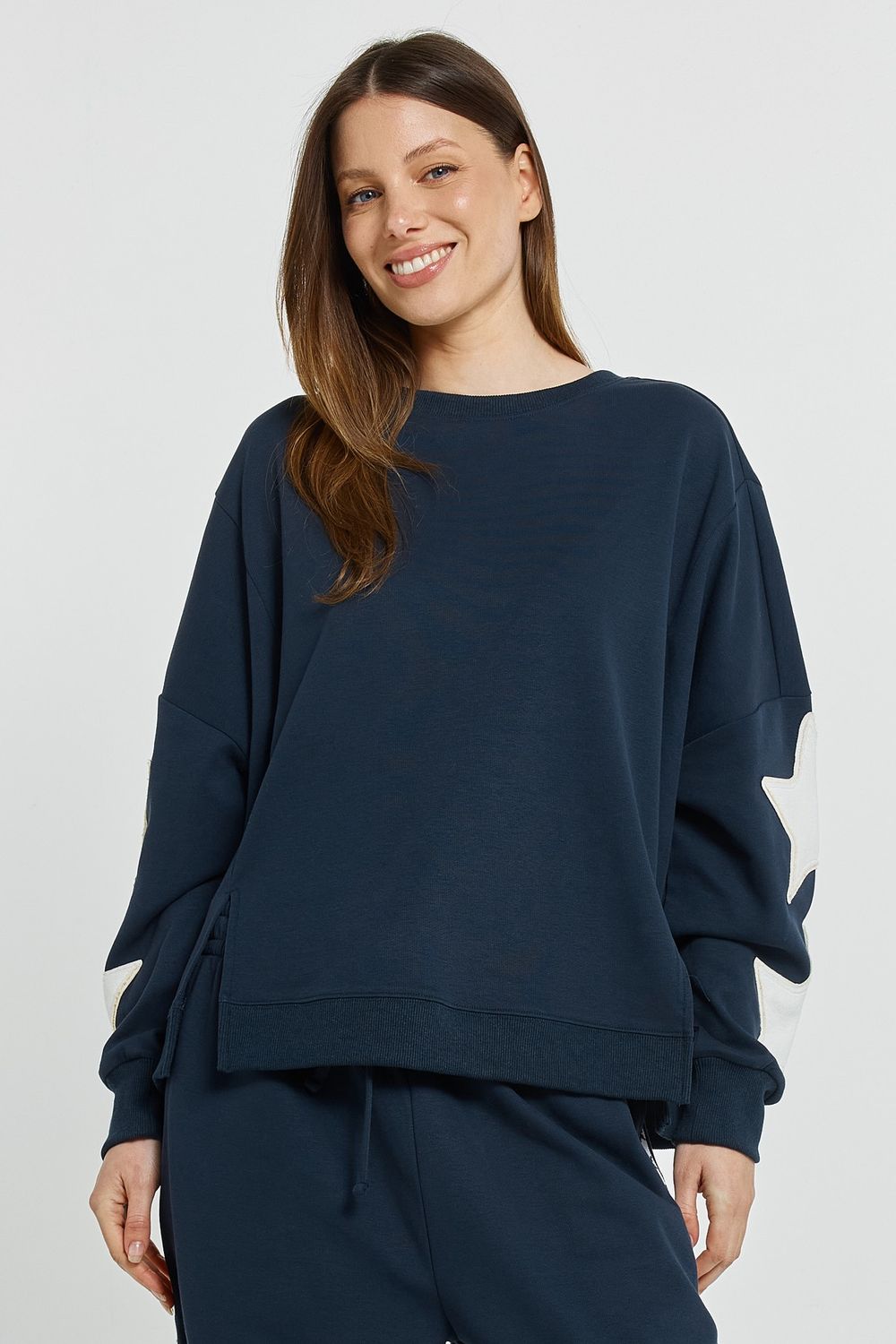 women wearing the Betty Basics Saskia Sweatshirt in Navy featuring 2 stars on each arm in white