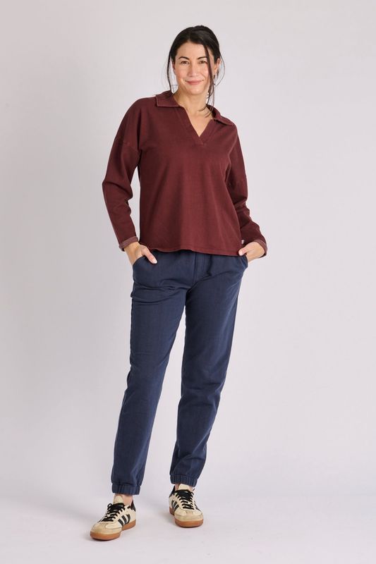 Full body model wearing the Collard Crew in Chocolate matching it back with a pair of navy blue straight legged pants. 