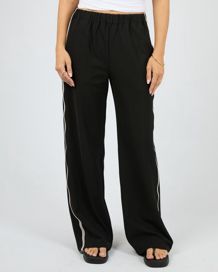 Women model wearing the Lina Pant in Black from All About Eve fearturing a black base with black and white ribbon stripes