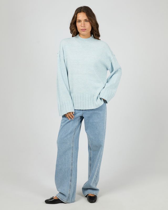 Full body view of the Silent theory Lotus knit matching it back with a pair of light blue denim jeans for the ultimate look