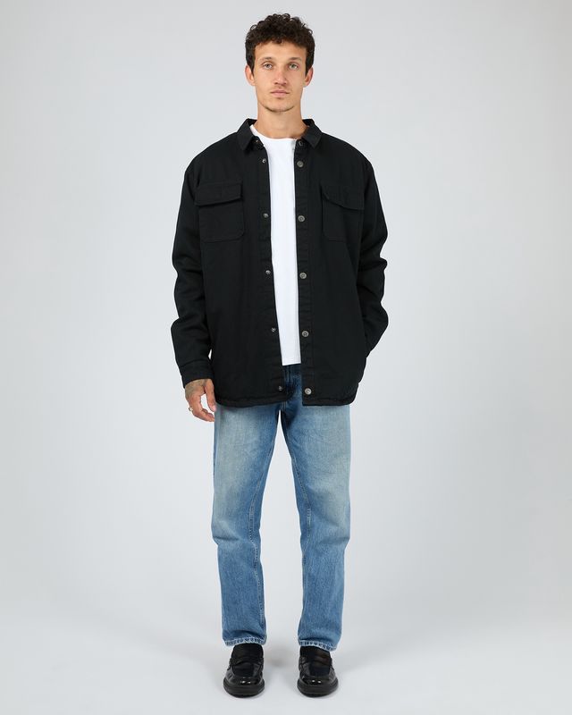 full length view of a man wearing the Riot Sherpa Shacket in Black with a white tee and blue jeans Showing the casual styling