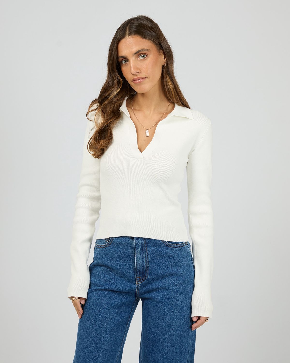 Women model wearing the All About Eve Cecilia Knit in vintage white a polo style knit with a v neckline