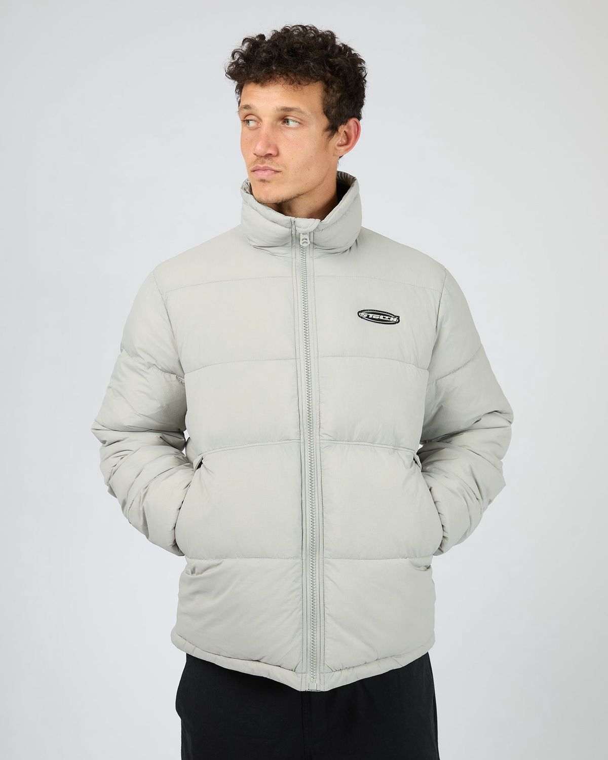 Man wearing the St Goliath Gravity Jacket with kangaroo pockets and the St Goliath Logo on the top             left

