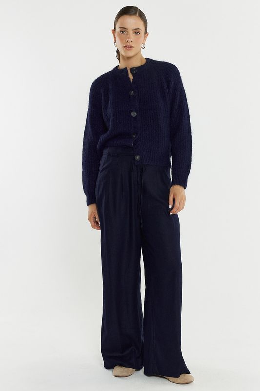 Full body view of the Posie Fluffy Cardi matching it back with flowy navy pants to make it all come together