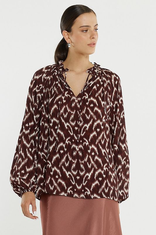 Women model wearing the Sass Willow Tie Front Blouse ikat showing the patterns and the flowiness 

