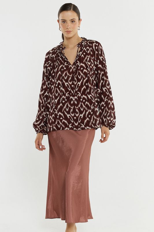 Full body Women model wearing the Sass Willow Tie Front Blouse ikat matching it back with a flowy rose gold skirt.