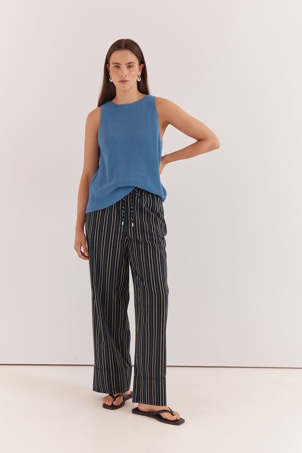 women model wearing the Sass Kiani Knit Tank in Blue featuring a blue knitted material in the shape of a tank top