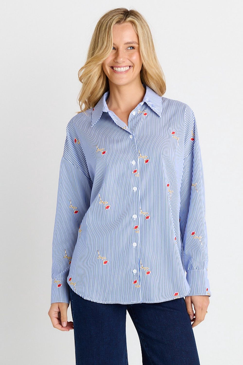 A female model wearing the Sass Sage Shirt featuring blue and white vertical stripes with roses throughout