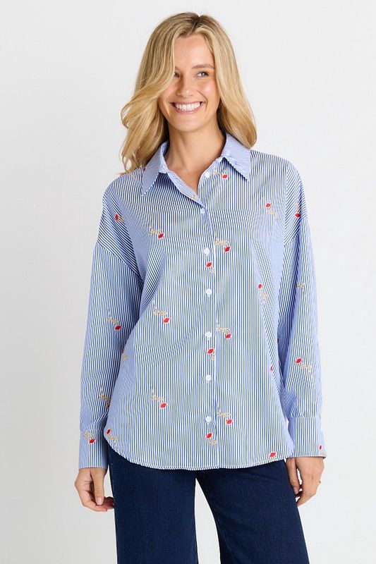 A female model wearing the Sass Sage Shirt featuring blue and white vertical stripes with roses throughout