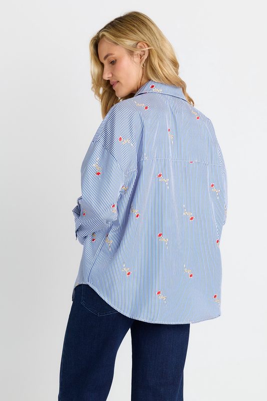 A back view of a women model wearing the Sass Sage Shirt showing the scooped hem in the back
