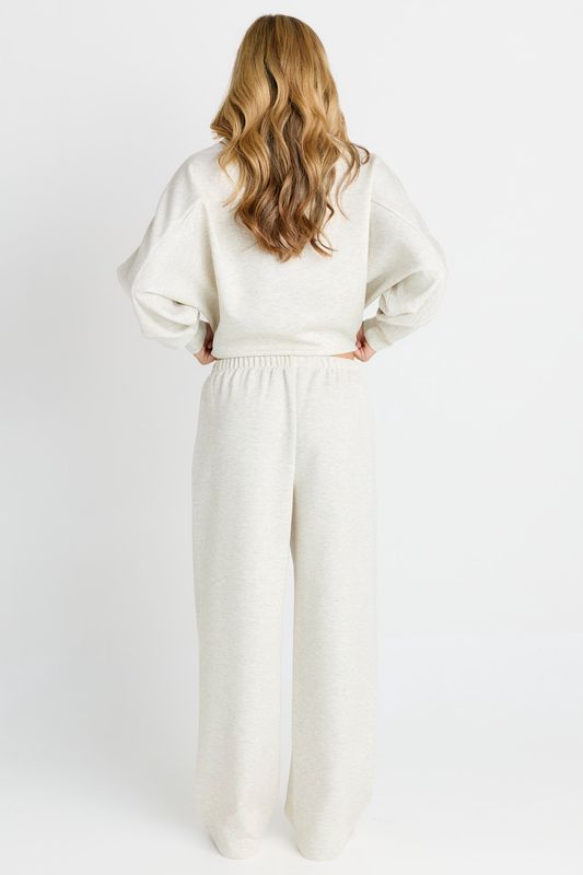 back view of a model wearing the Betty Basic Marcy Trackpant in grey featuring an elastic waist band wide leg fit