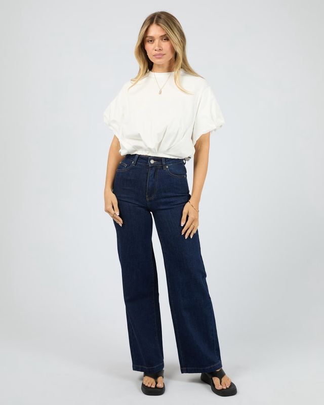 Full length view of women wearing the AAE Icon Bubble Tee in Vintage white with dark blue jeans. Giving a elevated looks
