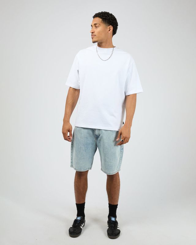Full body view of a male model wearing the Shadow A3 Short in Light Blue, matching it back with a plain white Tee. 
