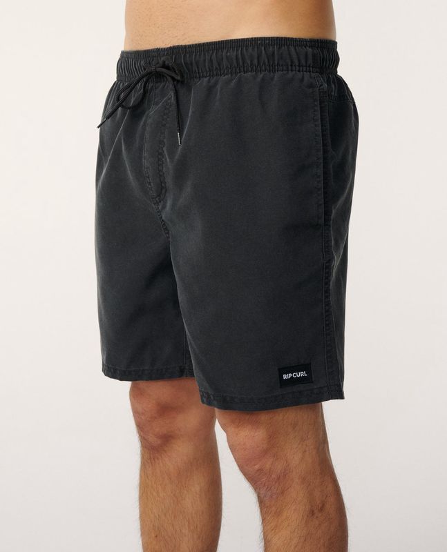 A male model wearing the Bondi Volley Short in Black featuring a elastic waistband and black drawstring. 