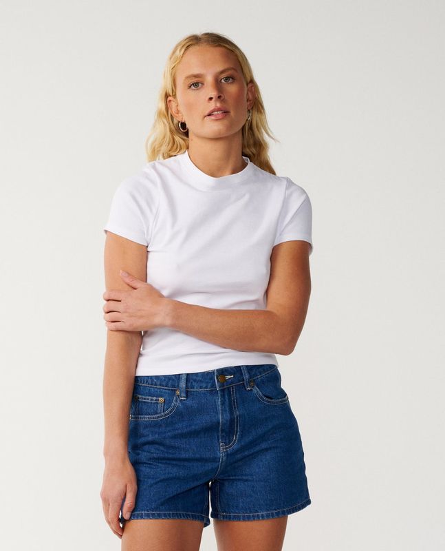 A female model wearing the Tabby Denim Short matching it back white a plain white tee for the ultimate look.