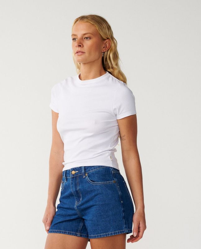 A female model wearing the Tabby denim short featuring 4 functional pockets.