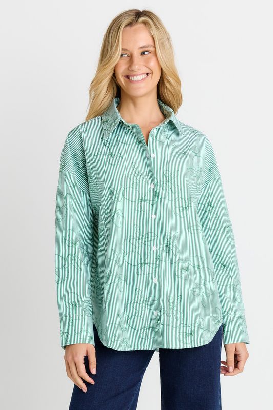 A female model wearing the Sage Shirt in Green stripe, featuring a button-up shirt with a relaxed fit and classic collar.