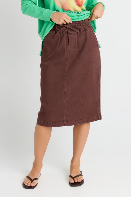 A female model wearing the Quinn Cotton Midi Skirt in Chocolate, featuring 2 functional pockets for all your essentials. 