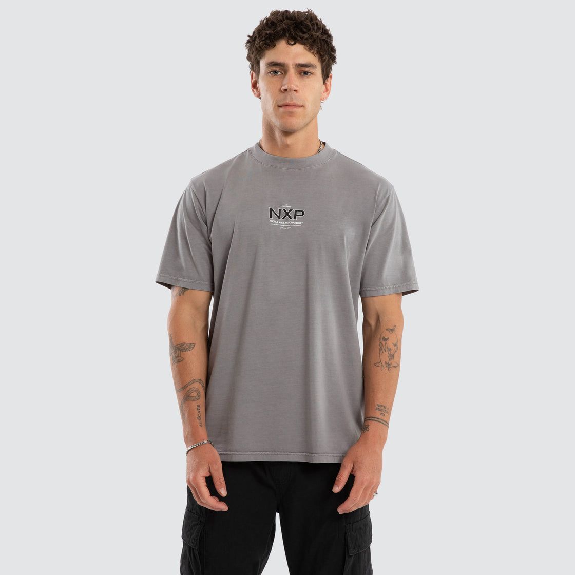 A male model wearing the Cendra Classic Tee, featuring  a grey colour, mid length and a flowy fit.
