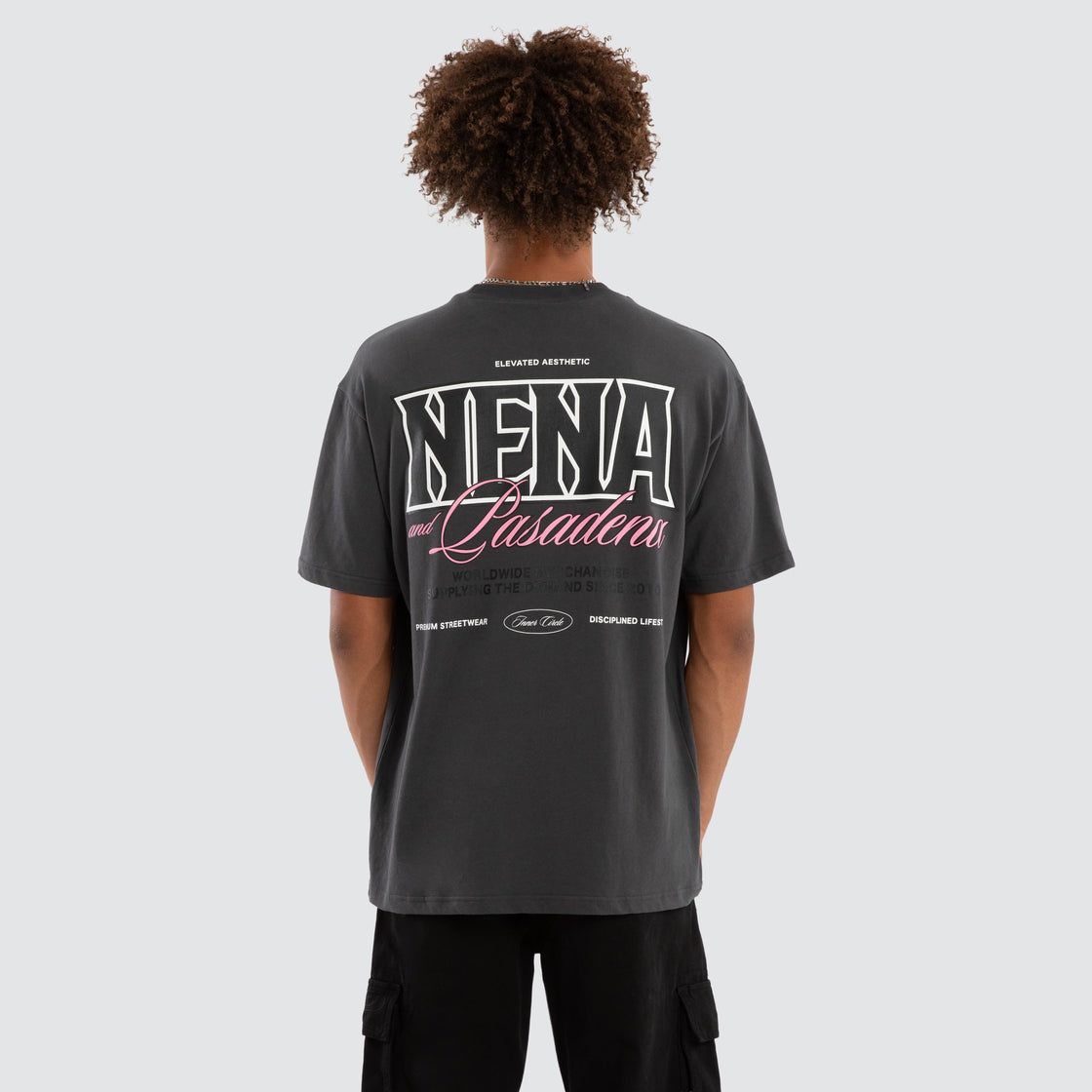 A male model wearing the Maurosa Box Fit Tee, featuring a bold NENA logo with pink writing on the back.