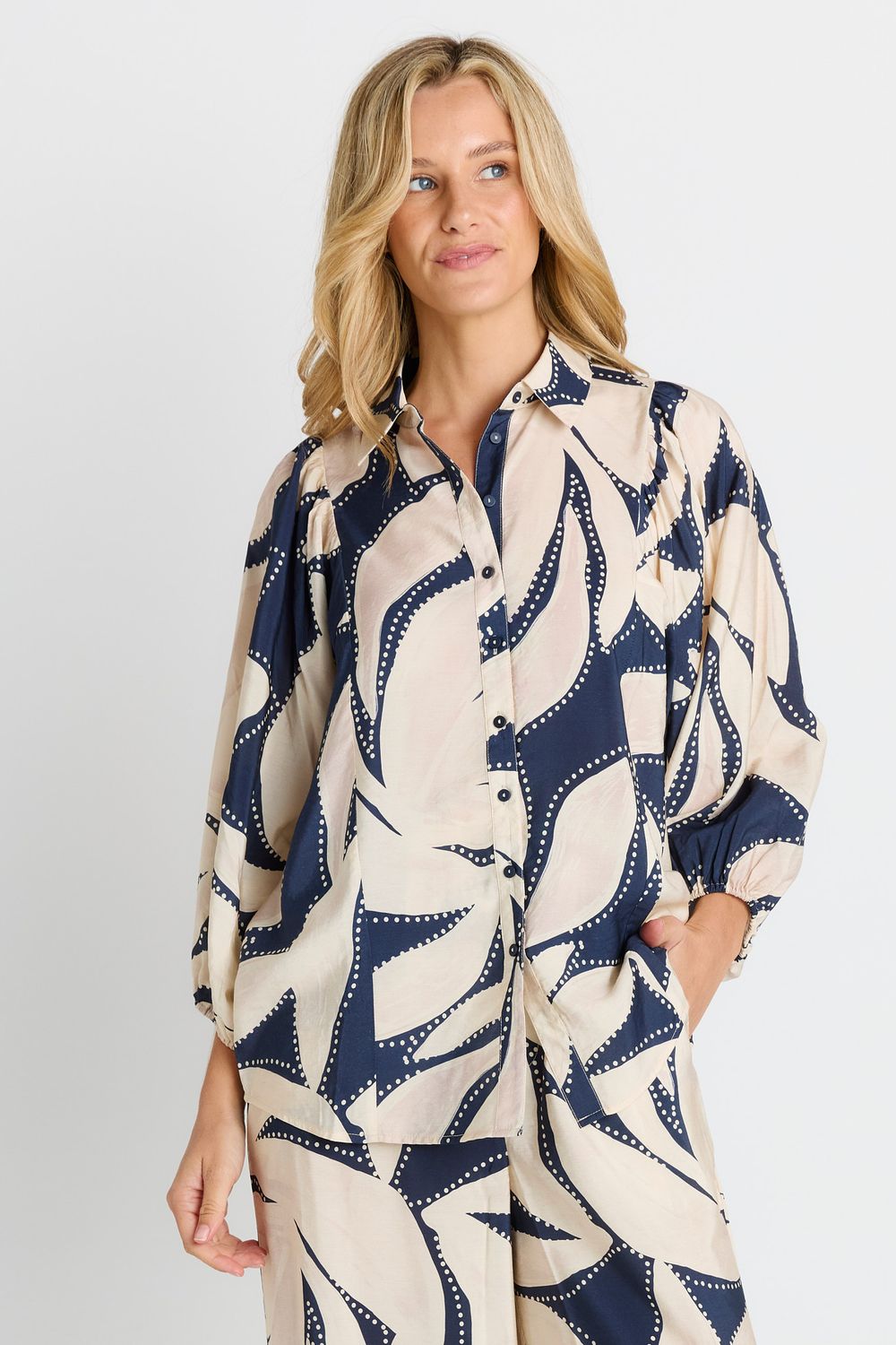 Model wearing the Nova Shirt in Navy Floral Print featuring abstract blue and white printed shirt with a relaxed fit.