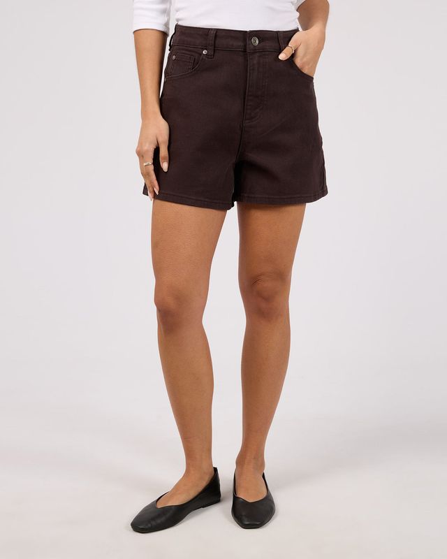 A female model wearing the Kyia Short Comfort in Chocolate showing length and 4 functional pockets.