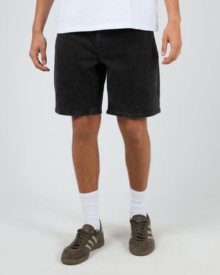 A male model wearing the Shadow A3 short in vintage black showing the mid length and relaxed fit.