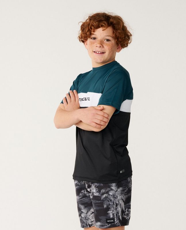 Side view of a boy model wearing the Undertow UPF S/S Swim Top [8-16YEARS] featuring quick dry technology .