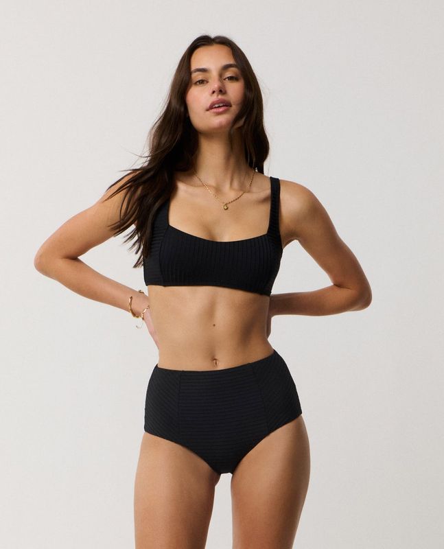 A female model wearing the RipCurl Premium Surf Multi Fit Crop featuring the black colour and high waist bottoms.