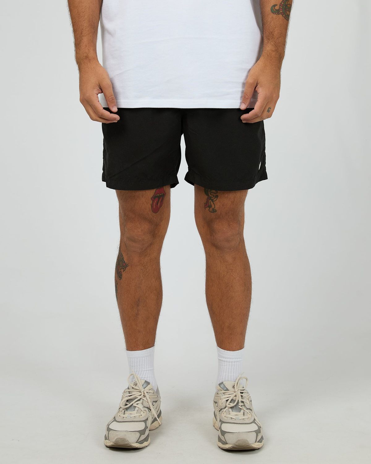 A male model wearing the ILLUSION Short in black, featuring light weight material and soft to the touch.
