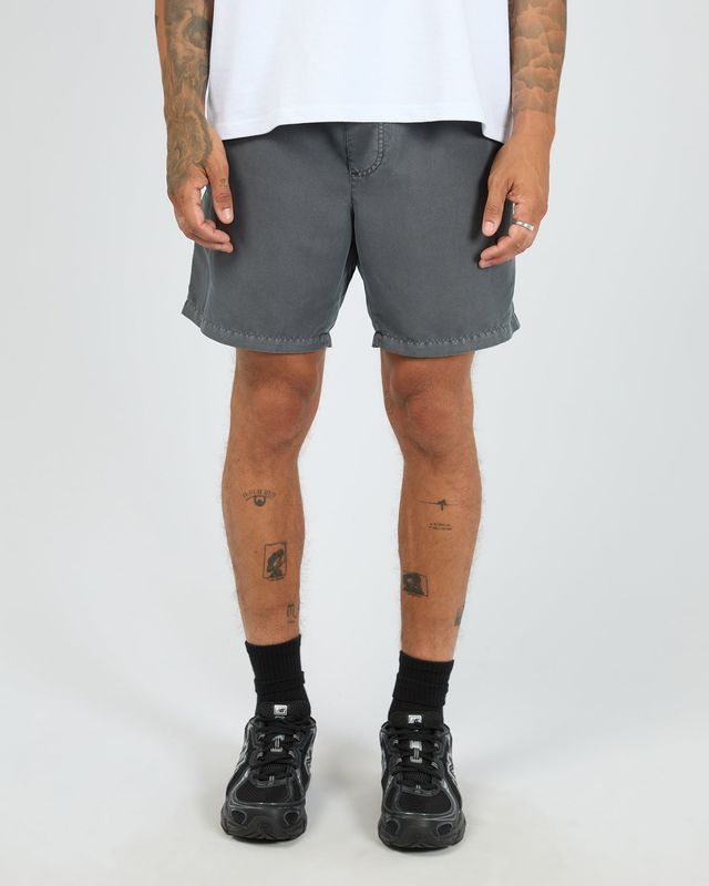 A male model wearing the ILLUSION Short in Coal, featuring light weight material and soft to the touch.