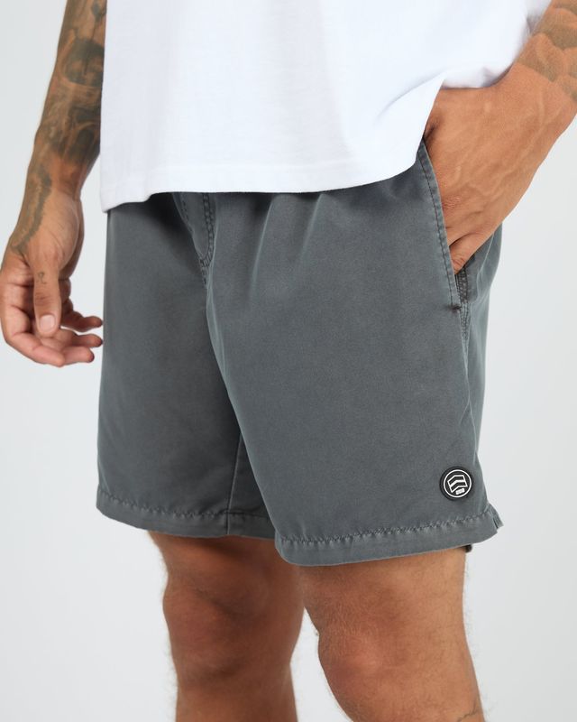 Close up of a male model wearing the ILLUSION Short in Coal, featuring a small ST.G logo and two function pockets.