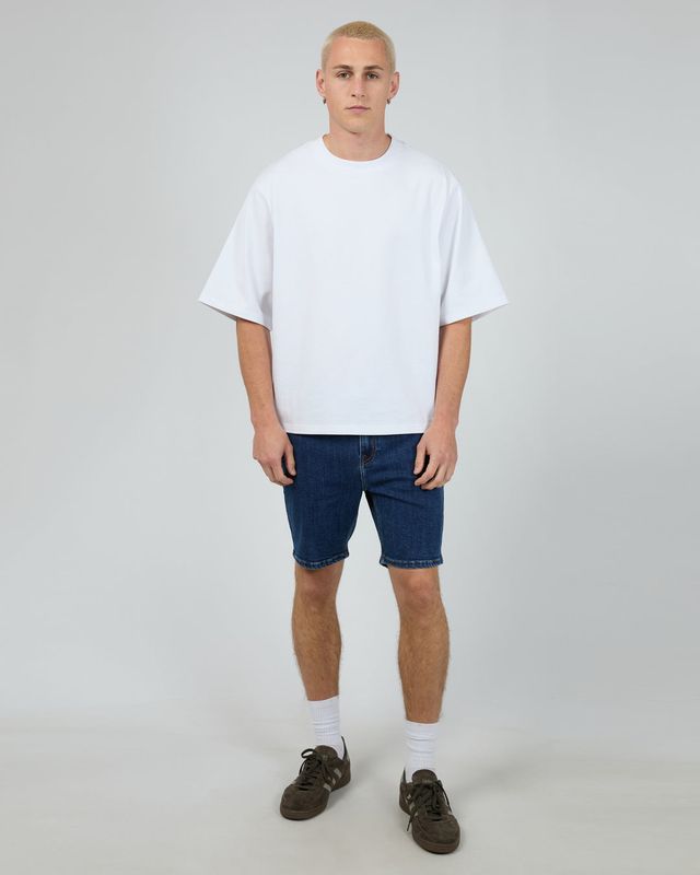 A male model wearing the Shadow A2 short in Blue matching it back with a white Tee for that casual look. 