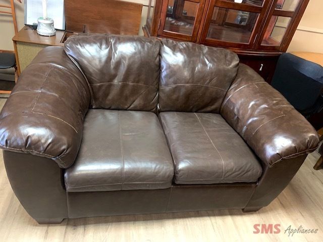 Brown leather couch. Dimensions: H- 35”, W- 62”, D- 38”