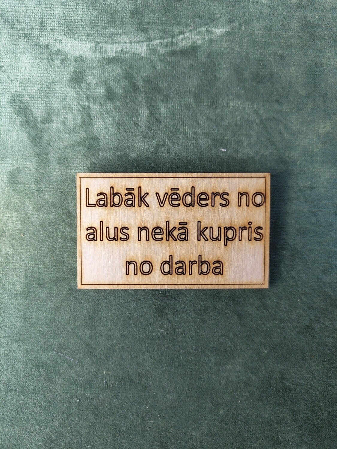 Koka magnēts ar sakāmvārdiem &quot;Labāk vēders no alus nekā kupris no darba&quot;