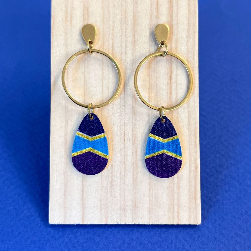 boucle d'oreille Bleu nuit, violet et turquoise sublimés par des lignes dorées dans un motif graphique et dynamique.