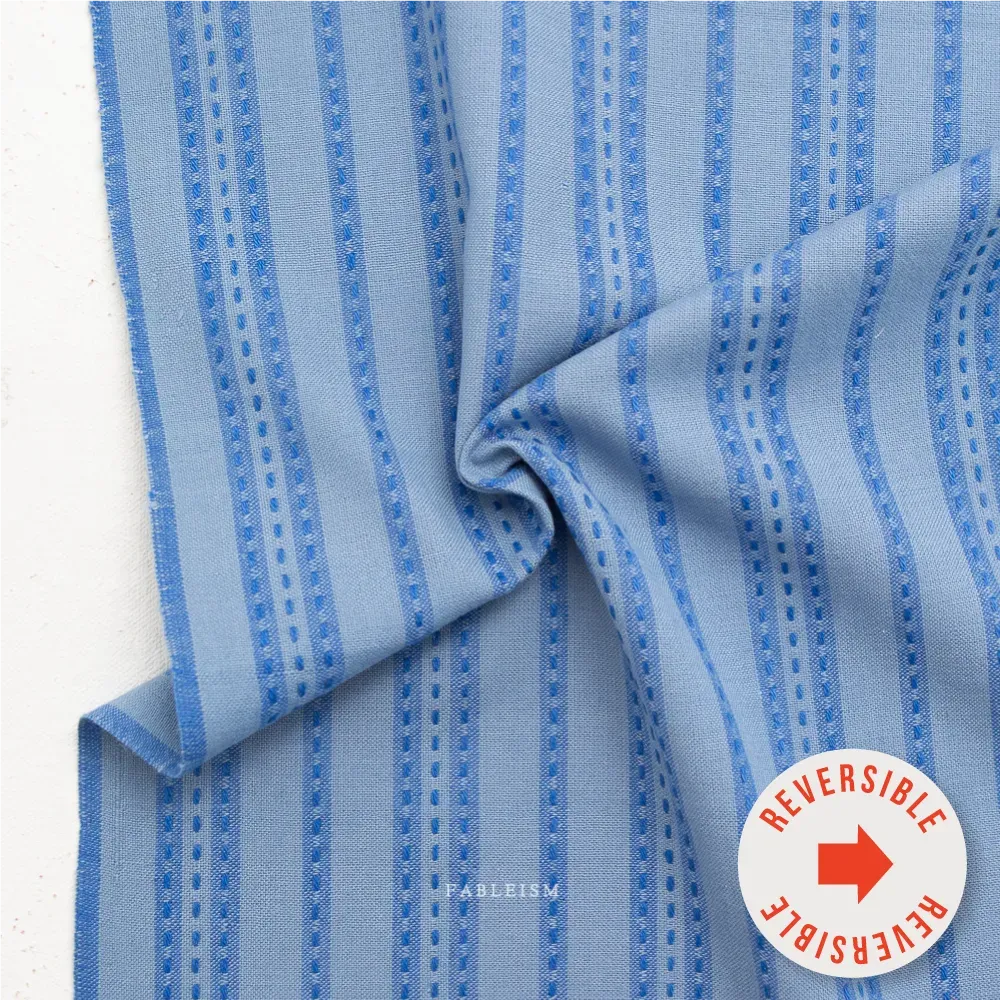 Stitch Stripe in Blue | Fine and Dandy | Fableism — reversibel Gewebter Baumwollstoff Stitch Stripe in Blue von Fableism aus der Kollektion Fine and Dandy mit blauem Streifenmuster.