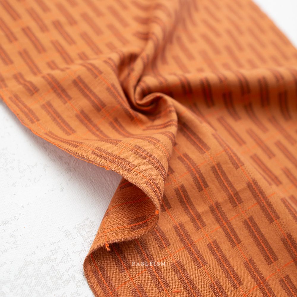 Gewebter Baumwollstoff Formation in Tawny aus der Kollektion Fine and Dandy von Fableism mit grafischem Muster.