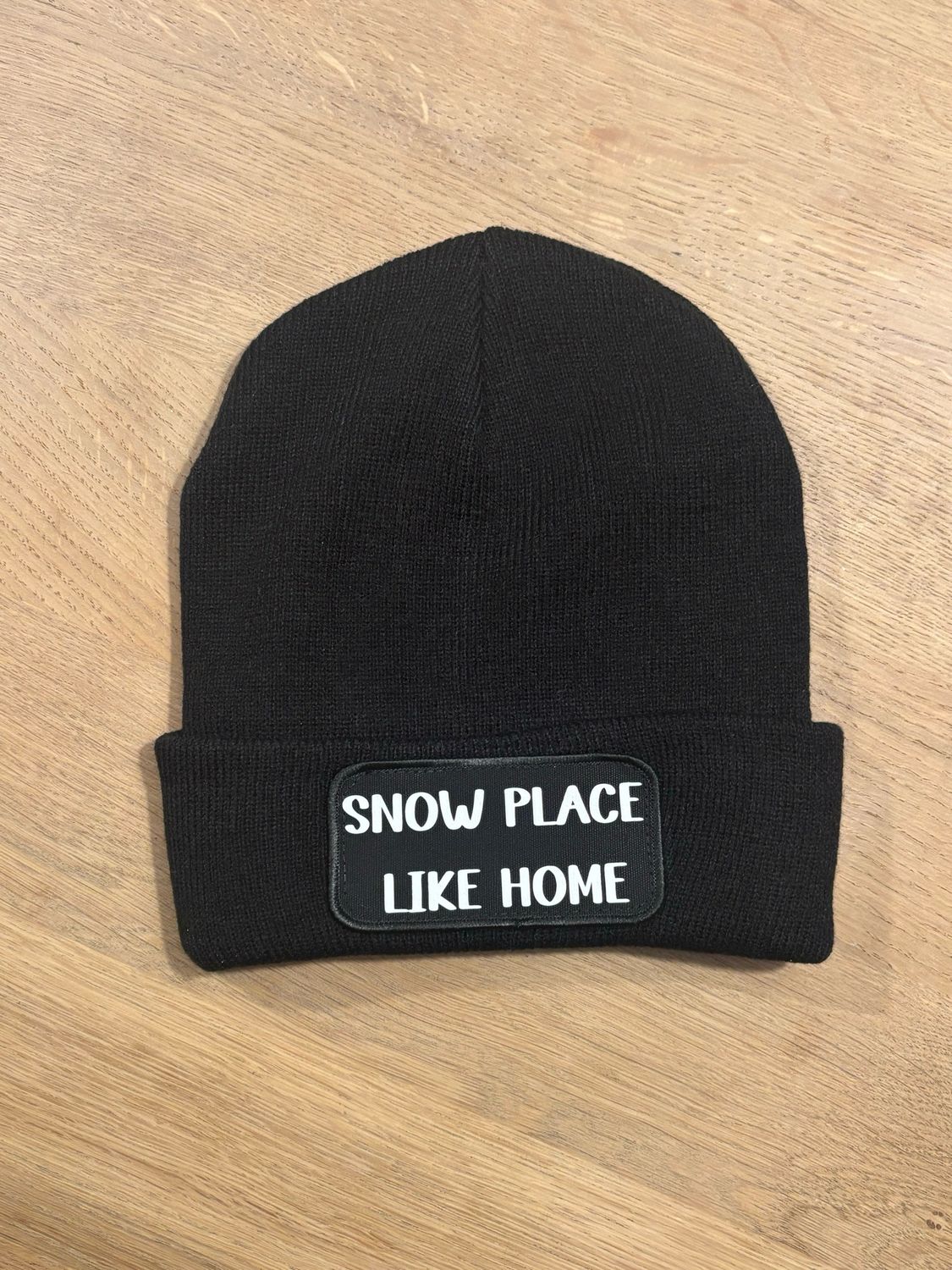 Muts / Beanie met tekst "Snow place like home". Zwarte muts met witte letters