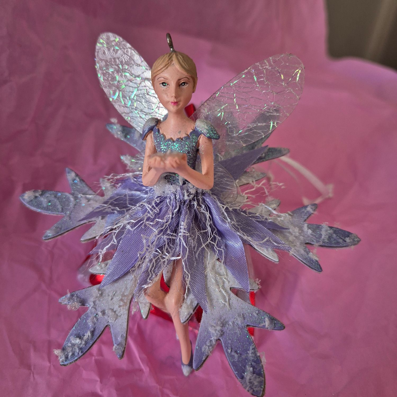 Fairy sitting on a bag of chocolates.
