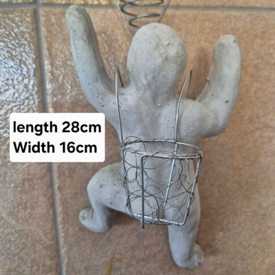 Cement climbing man with Tillandsia basket on back. Cement climbing man with Tillandsia basket on back.