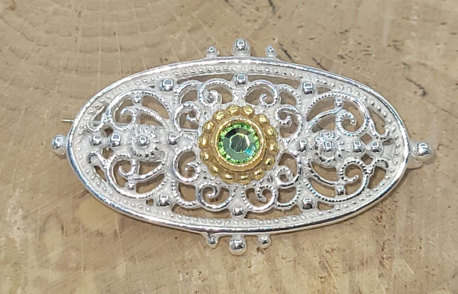 Trachtenbrosche in 925 Silber, Teilvergoldung. Steinfarbe: peridot